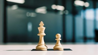 Ein Bild, das den Interessenkonflikt eines Datenschutzbeauftragten mit zwei Schachfiguren auf einem Feld symbolisiert.