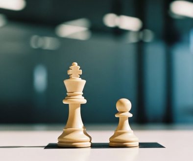 Ein Bild, das den Interessenkonflikt eines Datenschutzbeauftragten mit zwei Schachfiguren auf einem Feld symbolisiert.