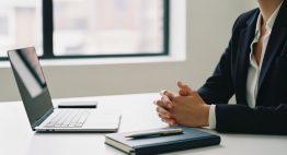 Eine Person sitzt an einem Schreibtisch und denkt über den korrekten Umgang mit Krankmeldungen nach.