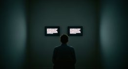 Eine Person sitzt vor zwei Bildschirmen und führt den Turing Test durch.
